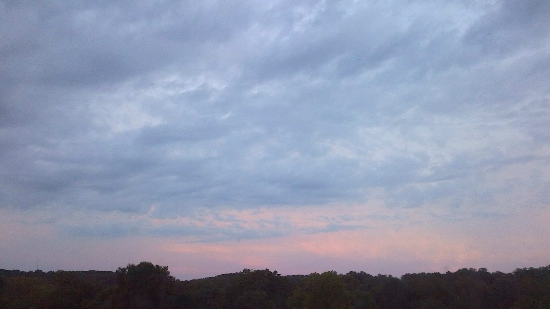 A sky filled with lots of clouds at dusk.